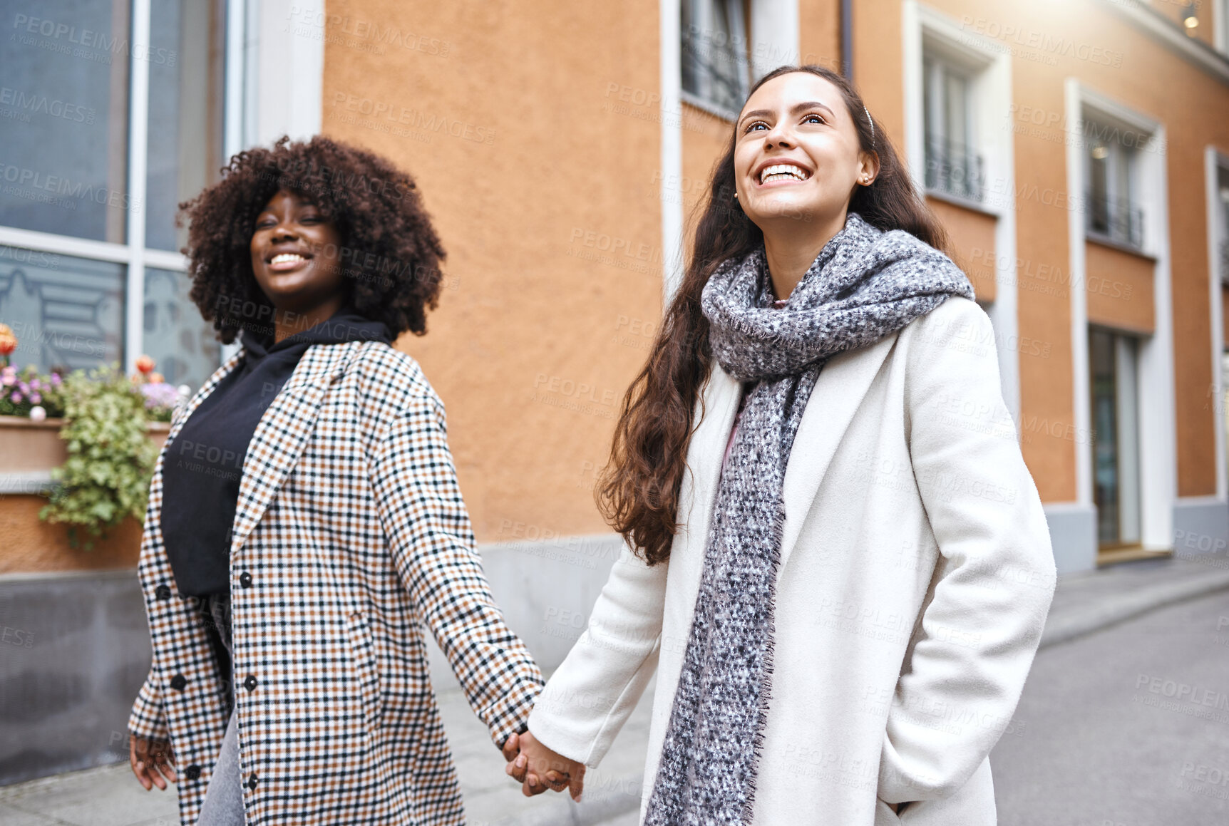 Buy stock photo Woman, friends and holding hands walking in the city for friendship, travel or fun journey in the outdoors. Happy women taking walk or stroll touching hand with smile for sightseeing in an urban town