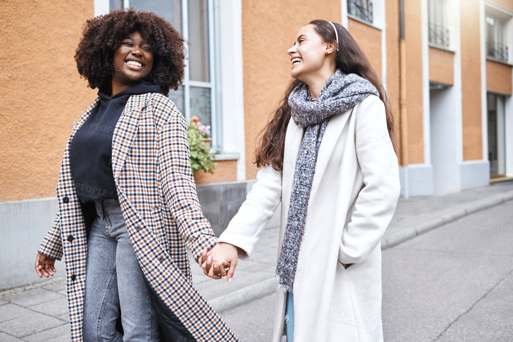 Buy stock photo Woman, friends and holding hands with smile in the city for friendship, travel or laughing for fun journey together. Happy women walking, touching hand and smiling for funny outdoor traveling in town