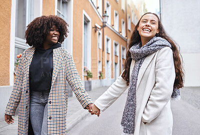 Buy stock photo Woman, friends and holding hands with smile for travel, friendship or fun journey together in the city. Happy women walking touching hand and smiling for funny outdoor traveling in an urban town