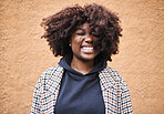 Black woman, smile and happy young person by an orange wall feeling freedom and joy. Happiness, urban fashion and cool laughing African female smiling with afro hair and stylish clothing outdoor