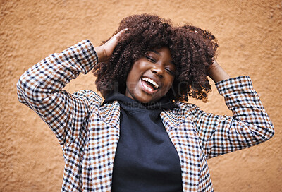 Buy stock photo Black woman, laughing and afro for fashion, style or hair against a wall background. Portrait of happy African American female model touching stylish curls and smiling in happiness for haircare