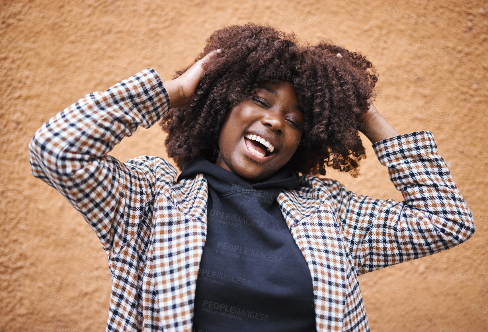 Buy stock photo Black woman, laughing and afro for fashion, style or hair against a wall background. Portrait of happy African American female model touching stylish curls and smiling in happiness for haircare