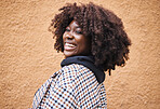 Black woman, portrait and laughing on wall background in city, urban town or fun in Kenya. Happy young african female smile for happiness, face and curly afro hair with fashion, motivation or freedom