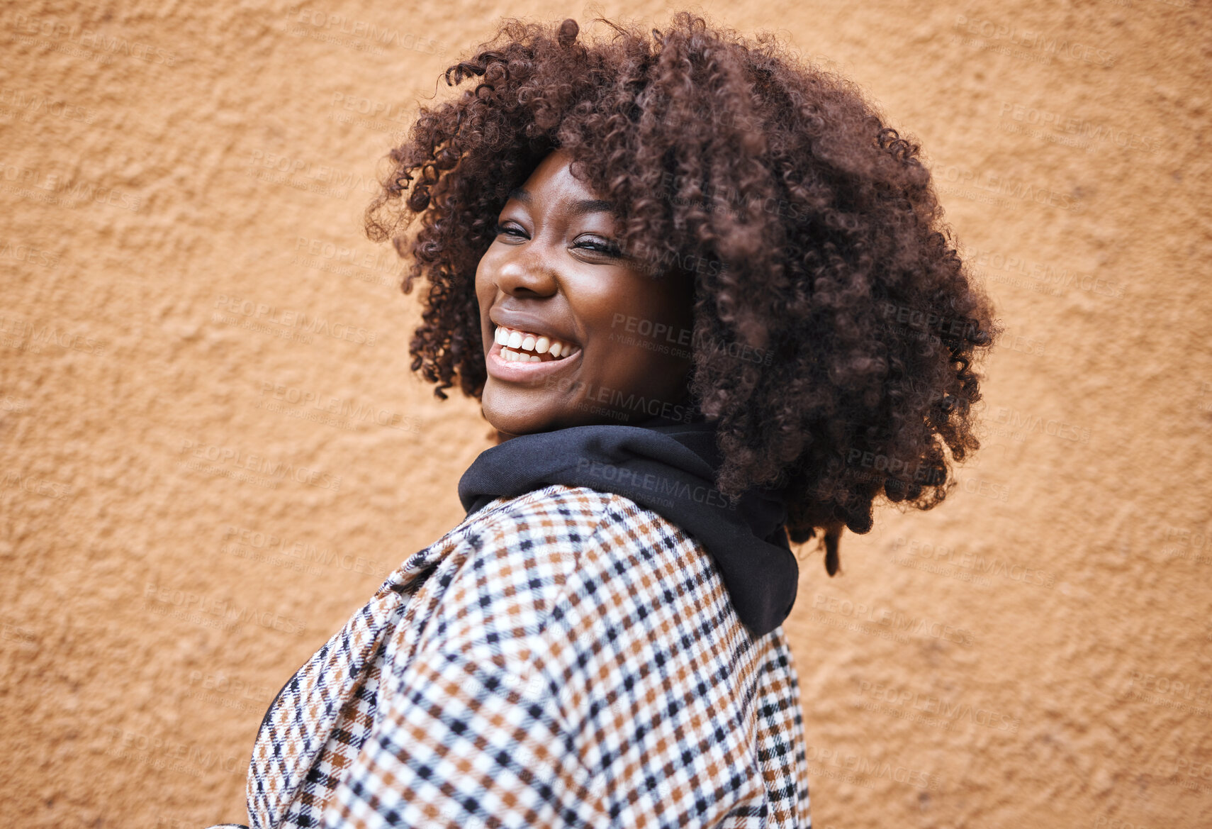 Buy stock photo Black woman, portrait and laughing on wall background in city, urban town or fun in Kenya. Happy young african female smile for happiness, face and curly afro hair with fashion, motivation or freedom