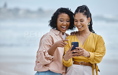Buy stock photo Phone, beach and social media with black woman friends outdoor together by the ocean or sea in the morning. Nature, mobile or internet with a young female and friend reading a text on the coast