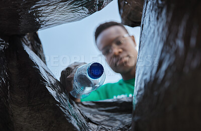Buy stock photo Recycle, bottle and black man with view in bag, sustainability and cleaning plastic pollution, earth day and community service. Saving the environment, charity and people putting trash in garbage bin