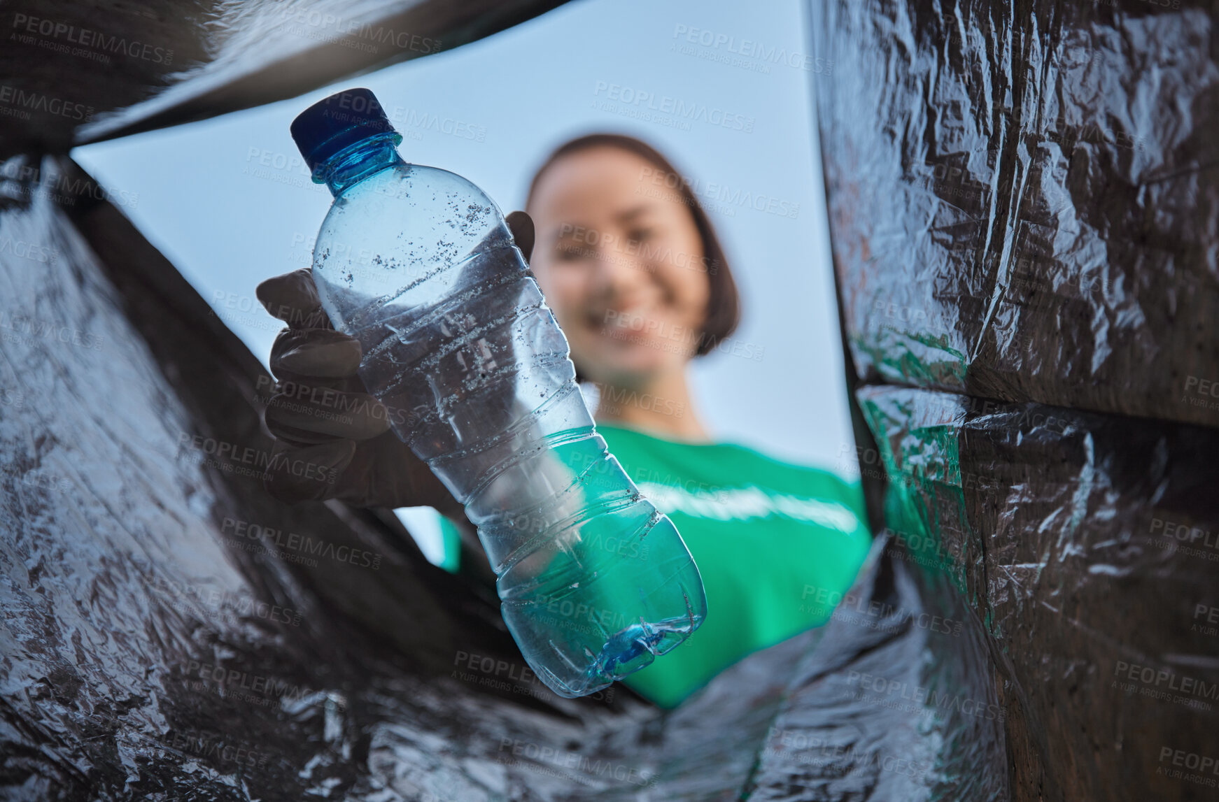 Buy stock photo Recycling, bottle and woman with view in bag, sustainability and cleaning plastic pollution, earth day and community service. Saving the environment, charity and people putting trash in garbage bin