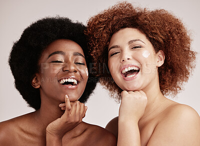 Buy stock photo Portrait, skincare and cream with black woman friends in studio on a gray background for antiging. Laugh, wellness or lotion and an attractive young female posing indoor with a model friend