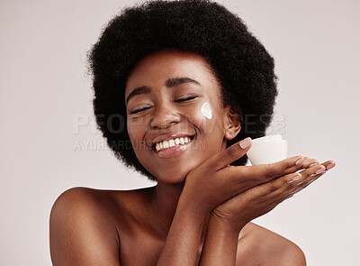 Buy stock photo Skincare, smile and black woman holding cream on face, afro and excited advertising luxury skin product promotion. Dermatology, spa cosmetics and facial for happy model isolated on studio background.