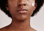 Black woman, face and cream of a model with facial mask, skincare and sunscreen in studio. Isolated, white background and self care treatment of a young person with cosmetic and collagen lotion