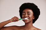 Brushing teeth, toothbrush and black woman for cleaning mouth on studio background. Face of happy person advertising dentist tips for dental care, hygiene and clean smile for healthy lifestyle
