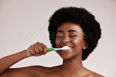 Buy stock photo Brushing teeth, toothbrush and black woman for cleaning mouth on studio background. Face of happy person advertising dentist tips for dental care, hygiene and clean smile for healthy lifestyle