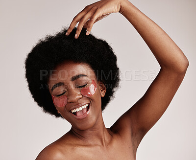 Buy stock photo Skincare, beauty and black woman with eye patches for anti ageing treatment isolated on grey background. Health, skin and model with afro, smile and collagen mask on eyes, luxury spa facial in studio
