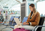 Airport, travel and woman typing on laptop in lobby, social media or internet browsing. Immigration, freelancer and female with computer for networking, web scrolling and waiting for flight departure