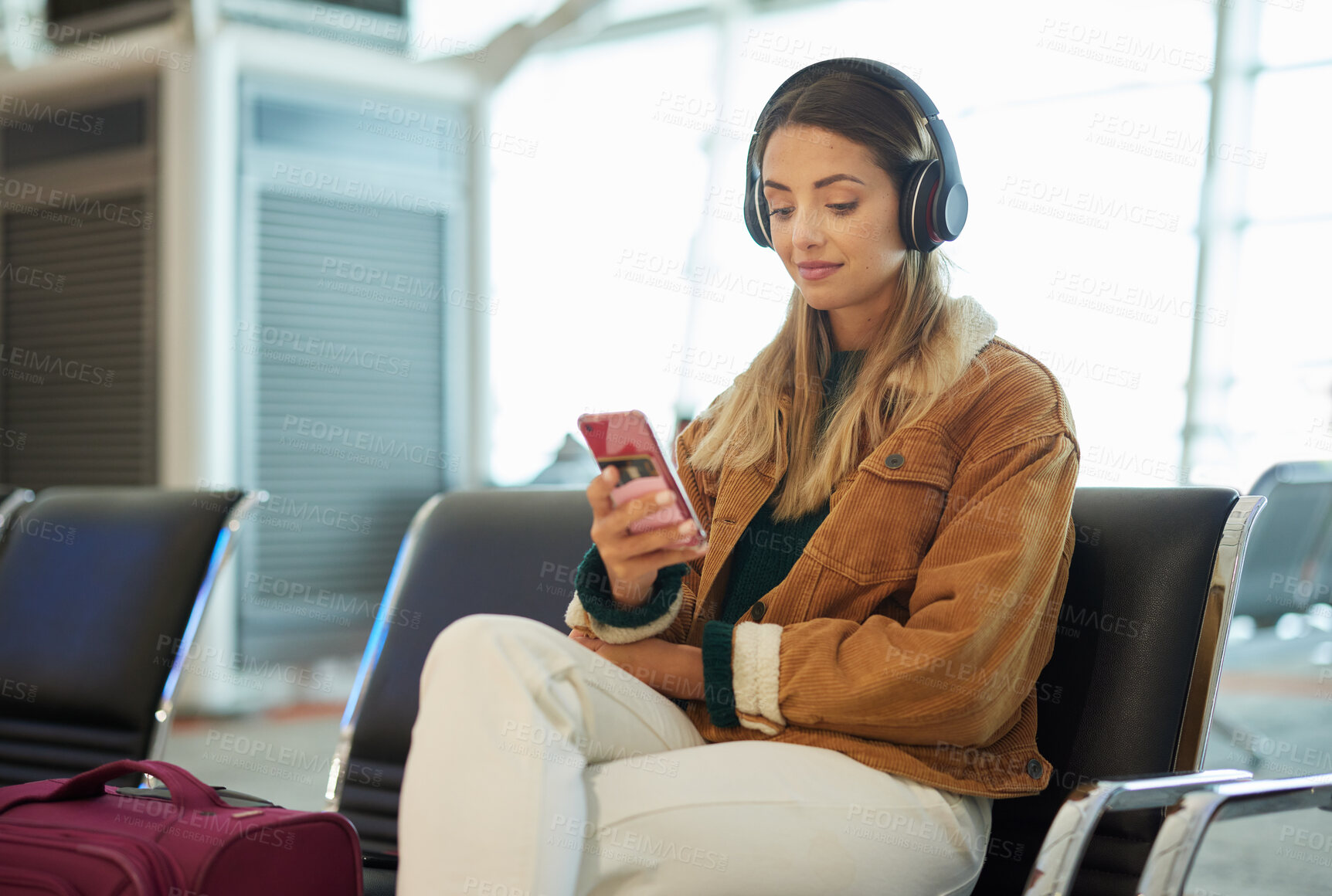Buy stock photo Music headphones, phone and woman at airport lobby on social media, internet browsing or web scrolling. Travel, mobile technology and female with smartphone app for streaming radio, podcast or song.