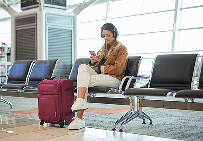 Buy stock photo Headphones, music phone and woman in airport lobby on social media, internet browsing or web scrolling. Travel flight, mobile technology and female with smartphone app for streaming radio or podcast.