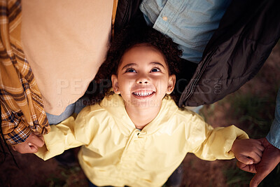 Buy stock photo Above, holding hands and face of a girl with parents for love, support and care in nature. Happy, fun and playful child with mother, father and affection in the countryside of Australia for bonding