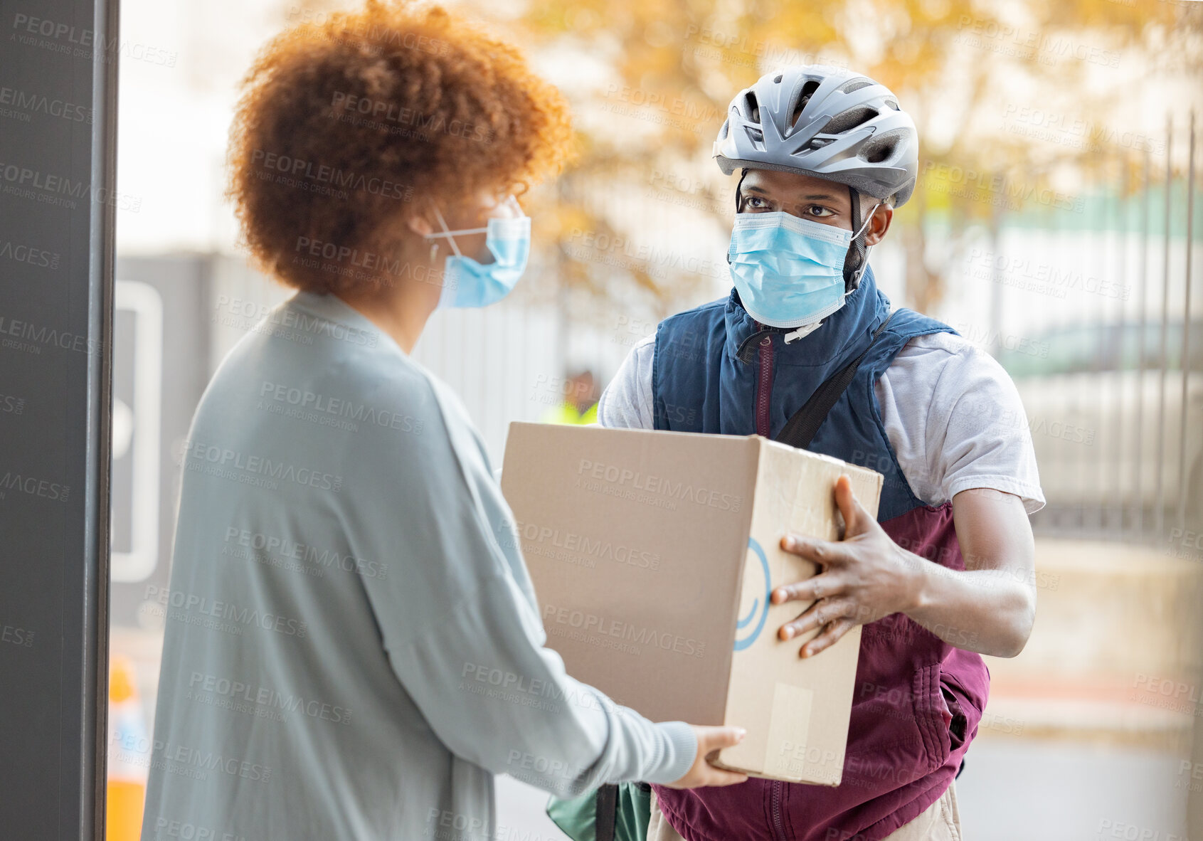 Buy stock photo Black man, mask and delivery with box for woman at house for logistics, cargo and safety from covid 19. Young african courier, package and shipping service with stock, helmet and e commerce in city