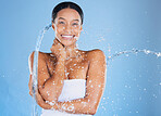 Happy black woman, portrait or water splash in showering, skincare grooming or sustainability wellness cleaning on isolated blue background. Smile, beauty model or wet drops in hydration dermatology