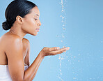 Beauty, water splash or washing hands for skincare grooming, healthcare wellness or sustainability cleaning on blue background. Black woman, model or wet shower drops for facial hydration dermatology