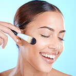 Makeup brush, cosmetics smile and woman face with makeup and happiness in a studio. Blue background, isolated and young person with eyes closed feeling calm from skincare and beauty with self care