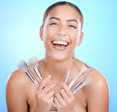 Buy stock photo Black woman, studio portrait and smile for makeup brushes in hands for face, natural beauty and blue background. Happy gen z model, cosmetics skincare and facial glow aesthetic for foundation product
