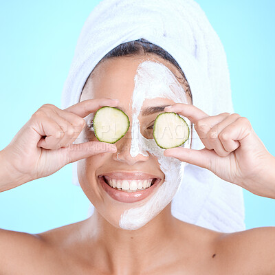 Buy stock photo Beauty, cucumber and skincare face mask on a woman with vegetable slice for dermatology cosmetics. Aesthetic model person with spa facial for self care, skin glow and wellness on blue background