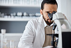 Science, microscope and analytics with a doctor man at work in a laboratory for innovation or development. Medical, research and biotechnology with a male scientist working in a lab for breakthrough