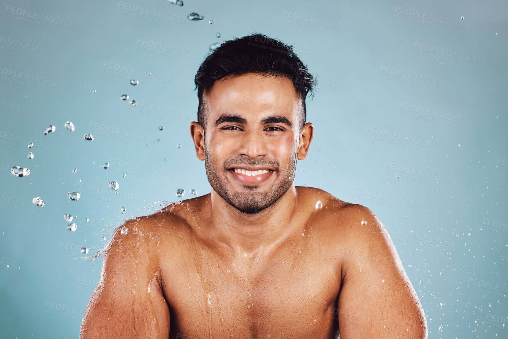 Buy stock photo Water drops, portrait and skincare man isolated on blue background face cleaning, body shower and smile. Strong, beauty model or person facial glow in studio headshot washing and dermatology hygiene