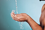 Man, water splash and hands in shower for skincare hygiene, wash or hydration against a studio background. Hand of young male model in beauty, wellness and washing or cleansing for clean body care