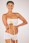 Health, tape measure and body with black woman and apple for nutrition and diet with fitness isolated on studio background. Portrait, smile and healthy lifestyle with weightloss and clean eating 