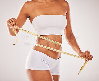 Buy stock photo Lose weight, body and woman with tape for stomach isolated on a grey studio background. Diet, health and girl measuring her waist for slim shape, motivation and belly while standing on a backdrop