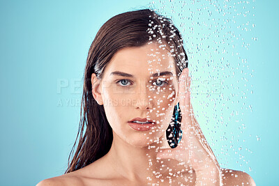 Buy stock photo Face, water splash and skincare of woman in shower in studio isolated on a blue background. Beauty, portrait and young female model washing, cleaning or bathing for hygiene, wellness and health.