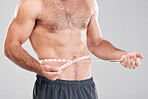 Health, diet and man with measuring tape on stomach, healthy exercise weight loss and body care. Sports, nutrition and fitness, tracking weight loss and six pack progress isolated on grey background.