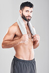Health, fitness and portrait of man with towel on neck after sports workout, sweat and hygiene isolated on grey background. Coach, personal trainer and smile, body care mindset for exercise in studio