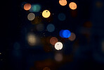 Bokeh, night and light on a window with water drops, liquid or moisture against a dark abstract background. Blurred lights, colorful and rain drop or splash on glass for city view during rainy season