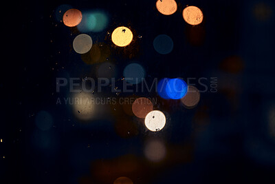 Buy stock photo Bokeh, night and light on a window with water drops, liquid or moisture against a dark abstract background. Blurred lights, colorful and rain drop or splash on glass for city view during rainy season