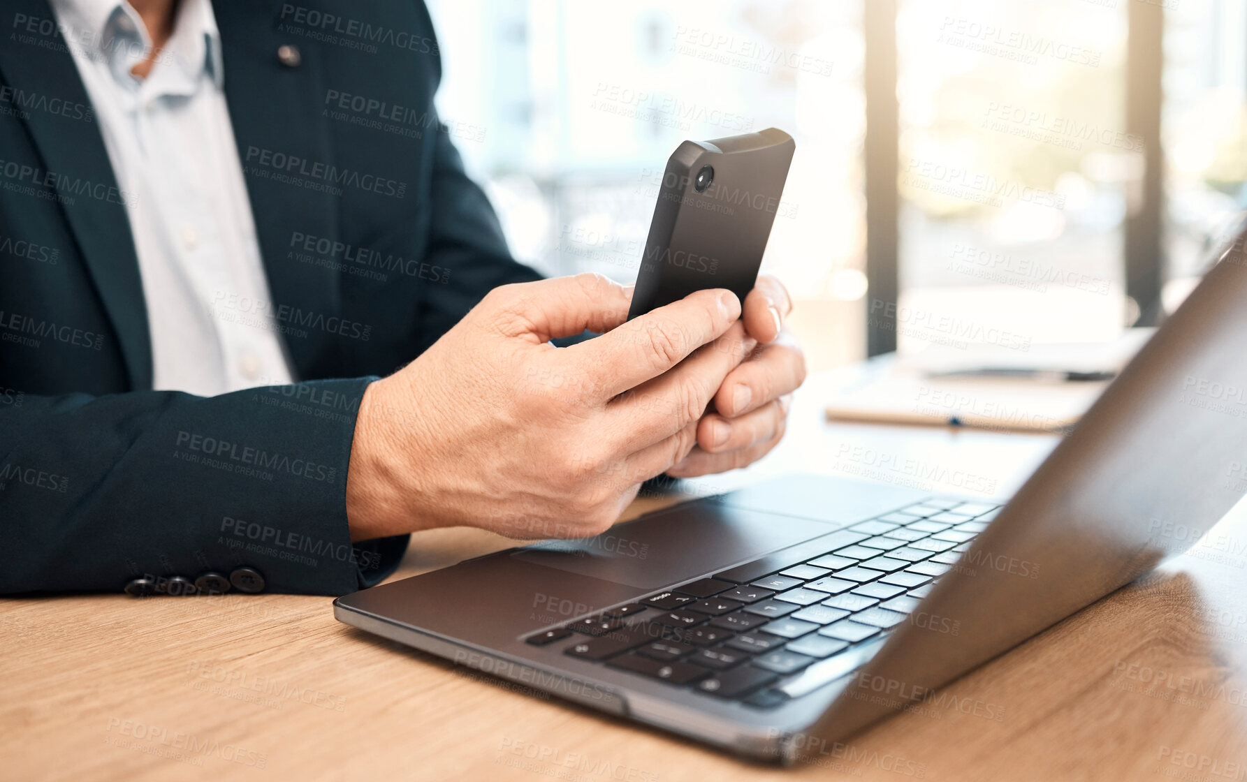 Buy stock photo Hands, phone and laptop with a business man doing research in his office while typing a text message. Mobile, communication and networking with a male manager or employee reading an email at work