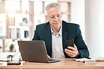 Laptop, phone and senior business man at desk working online, reading website and internet research. Office, communication and male worker on smartphone for networking, mobile app and social media