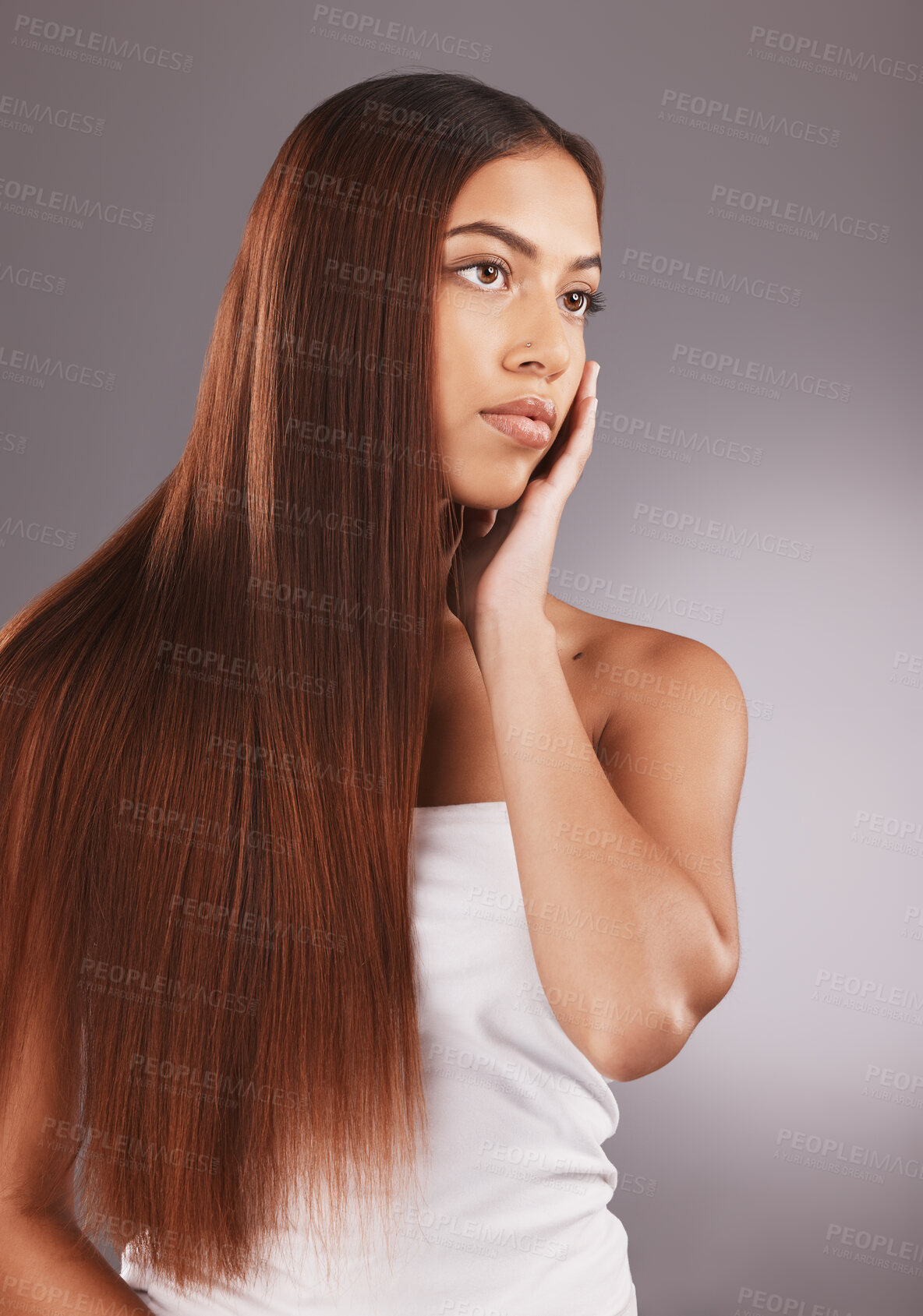 Buy stock photo Woman, long hair and face for skincare, beauty or cosmetics against a gray studio background. Attractive female touching skin in satisfaction for self love or facial, haircare and cosmetic treatment