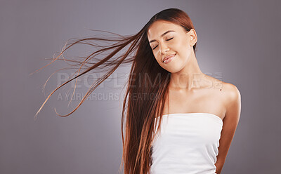 Buy stock photo Salon, hair and hairstyle by woman with care, glow and healthy skincare isolated in a studio gray background. Young, skin and natural beauty model smile due to keratin treatment for haircare