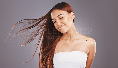 Buy stock photo Happy, hair and hairstyle by woman with smooth, glow and healthy skincare isolated in a studio gray background. Young, skin and natural model smile due to keratin treatment for haircare