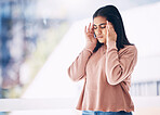 Headache, burnout or anxiety with an indian woman on a blurred background suffering from pain or stress. Compliance, mental health or mistake and a frustrated young female struggling with a migraine