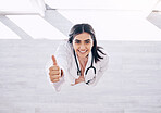 Top view, portrait or doctor thumbs up for success, vote or clinic approval for hospital life insurance or winner trust on mock up. Smile, happy or yes hands for healthcare worker woman in wellness