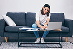 Woman, laptop and writing notes on living room sofa in remote work or studying on table at home. Female freelancer working with smile for planning, strategy or notebook by computer sitting on couch