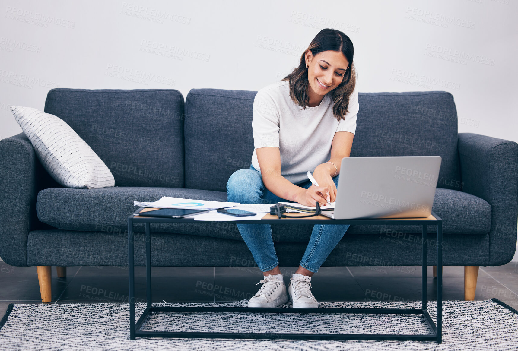 Buy stock photo Woman, laptop and writing notes on living room sofa in remote work or studying on table at home. Female freelancer working with smile for planning, strategy or notebook by computer sitting on couch