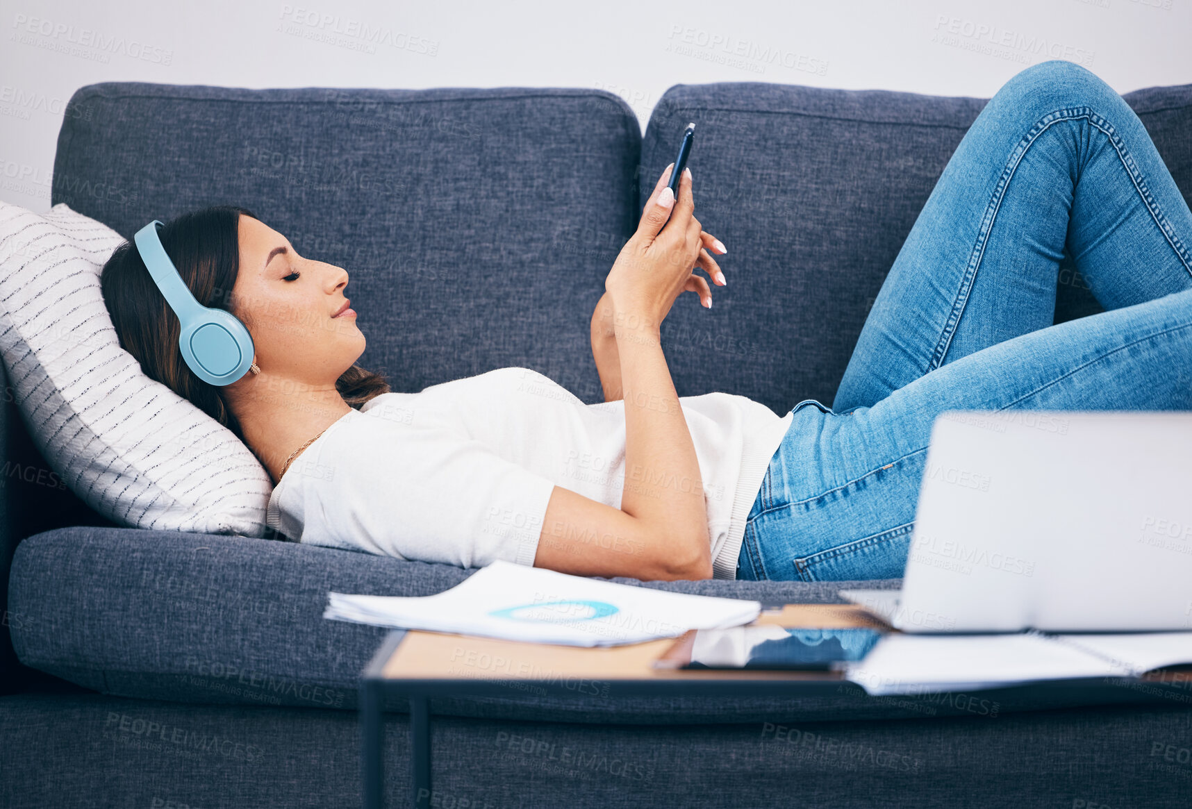Buy stock photo Headphones, sofa and woman student on study break for mental health, relax podcast and music streaming services. Smartphone, listening to audio and young person on couch with calm mindset or wellness
