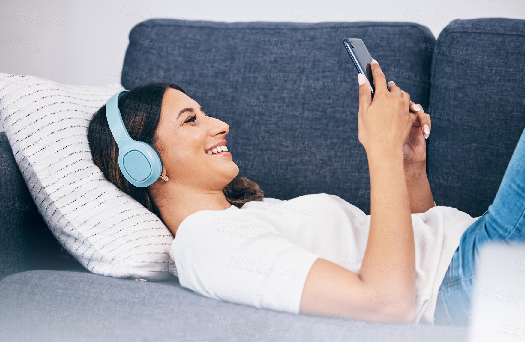 Buy stock photo Headphones, phone and sofa woman or student with meme video, internet chat and music for mental health and relax. Smartphone of person on couch streaming, listening to audio or a funny podcast online