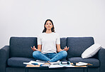 Studying, meditation and Indian woman in a living room with zen to relax from book learning. Sofa, home and female student meditate on a couch doing yoga for wellness in a house with education book