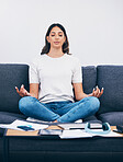 Zen, meditation and Indian woman in a living room with yoga to relax from book learning. Sofa, home and female student meditate on a couch doing wellness exercise in a house with education notebook